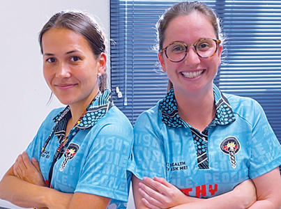 Two healthcare professionals smiling at the camera