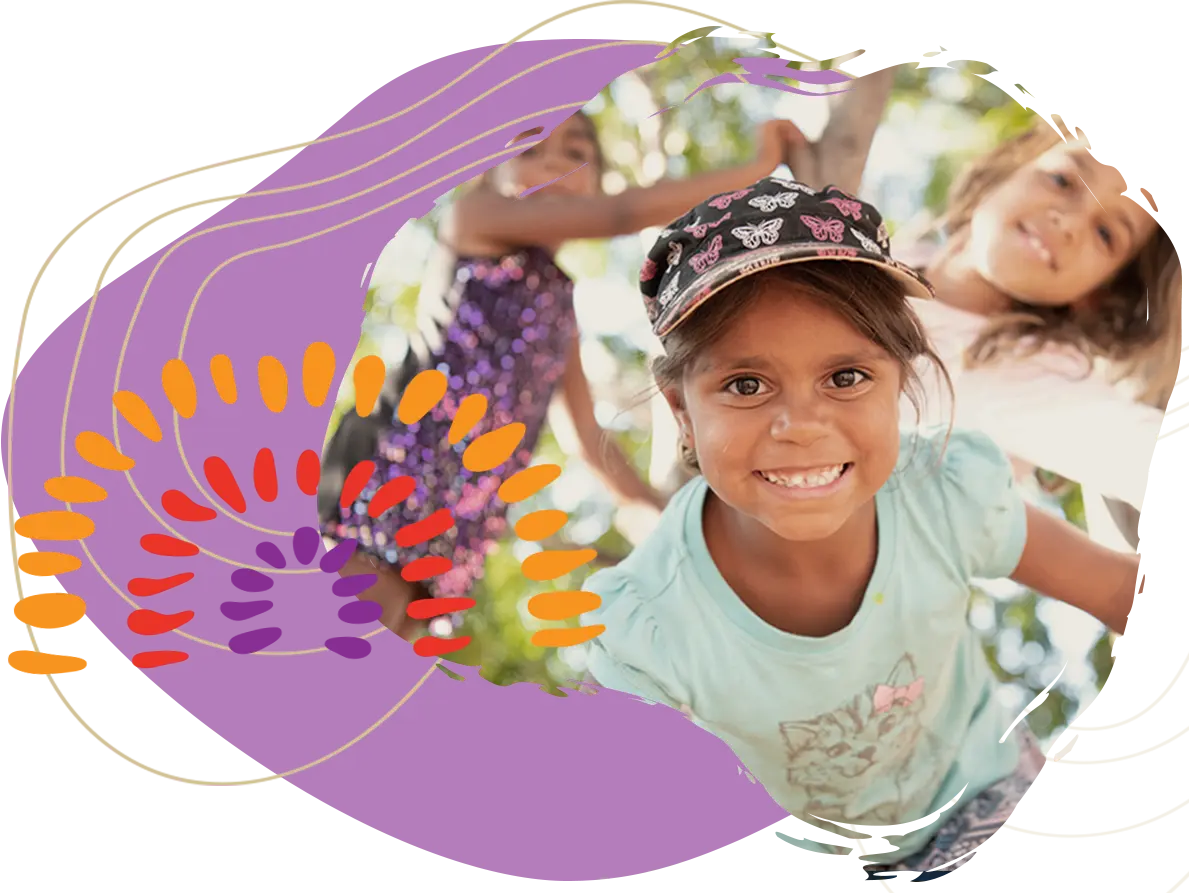Photo of a young Aboriginal girls smiling and playing with orange, red and purple Aboriginal art